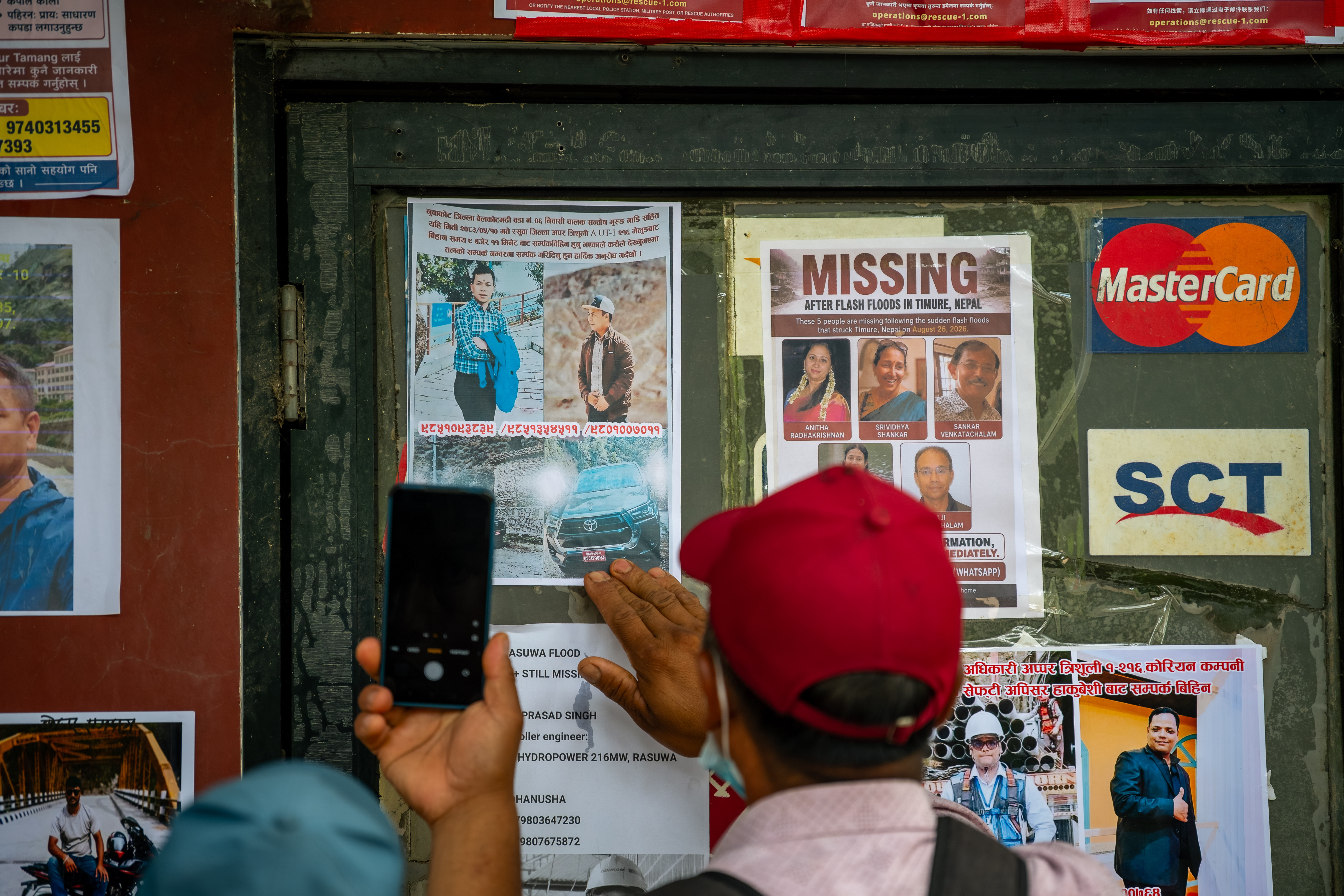 More than 5,600 people are still missing following the catastrophic flash floods in Nepal. The board in the photograph is covered with pictures of some of the missing in Devighat.